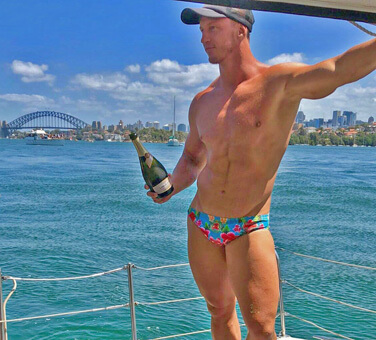 topless waiter in speedos serving champagne