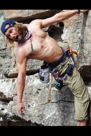 auckland based life drawing model showing off his fitness and strength on a rock climbing wall