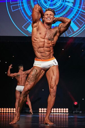 tattooed and tanned life drawing class model posing at new zealand physique  competition
