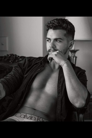 tattooed hens night topless host with model looks relaxing in an armchair in his undies near parnell