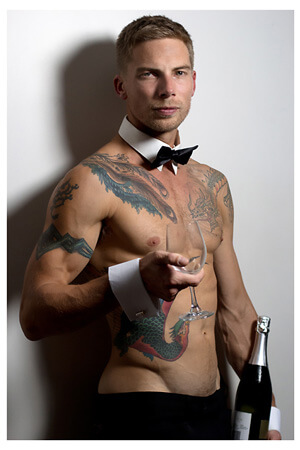 colourfully tattooed topless barman serving drinks in auckland's panmure