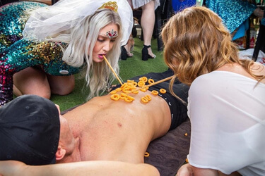 Hens playing a party game with a topless waiter at a hens night
