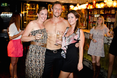 Hens celebrating with a topless entertainer at a bar