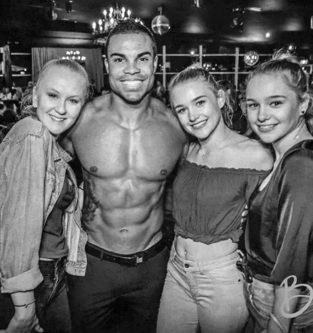 Male stripper entertaining a hens party group
