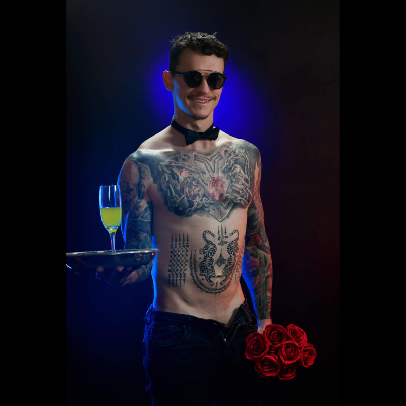 Tattooed topless waiter serving champagne and roses at a hens party